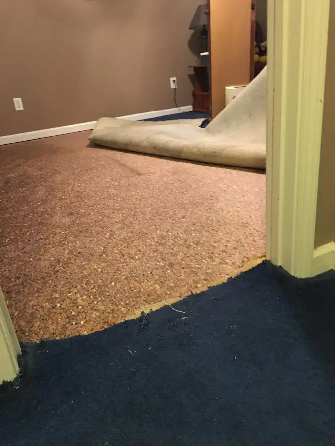Carpet pad removal revealing water damage during Water Mitigation Services in Minooka